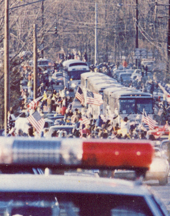 Crowds lining the road with American flags to welcome home the Iran hostages, January 1981
